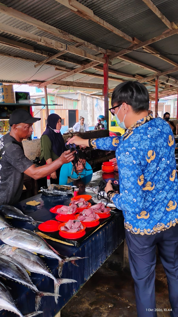 BPBD Kaimana membagi masker kepada masyarakat di kawasan pasar ikan.
